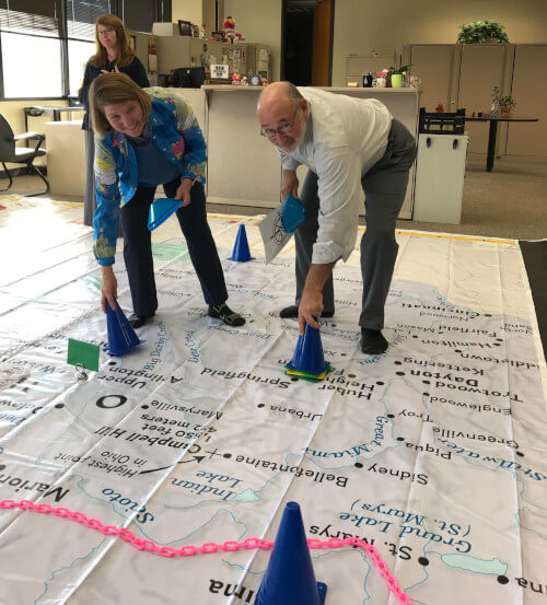 Rebecca Theobald and a teacher begin the On the Move lesson on the Giant Map of Ohio.