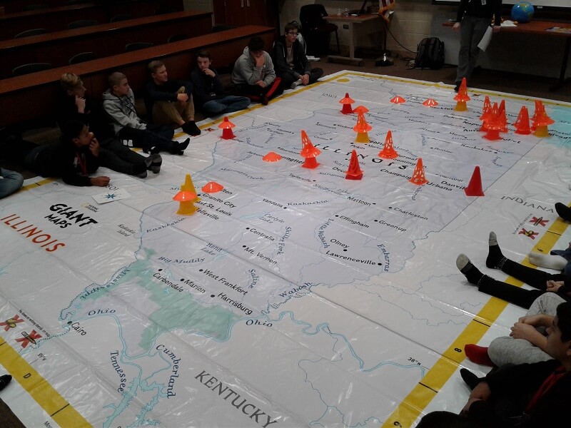 Students sit around the Giant Map of Illinois before the activity starts.